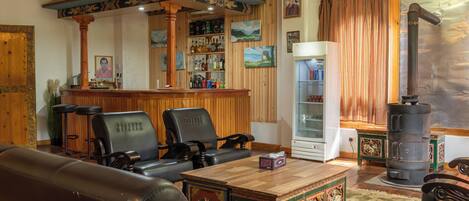 A traditional interior with wooden furniture, a bar area, and a decorative stove.