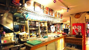 A bar area with shelves of bottles, glasses, and a coffee machine. - The Bavana Surawong Bangkok (Bangkok)