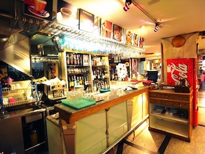 A bar area with shelves of bottles, glasses, and a coffee machine. - The Bavana Surawong Bangkok (Bangkok)