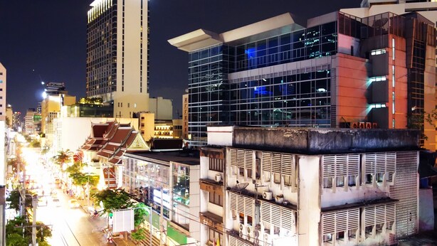 A nighttime cityscape with modern buildings, a busy street, and a prominent ATM sign. - The Bavana Surawong Bangkok (Bangkok)