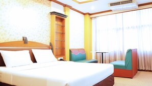 A hotel room with a bed, a small table, a chair, and a window with curtains. - The Bavana Surawong Bangkok (Bangkok)