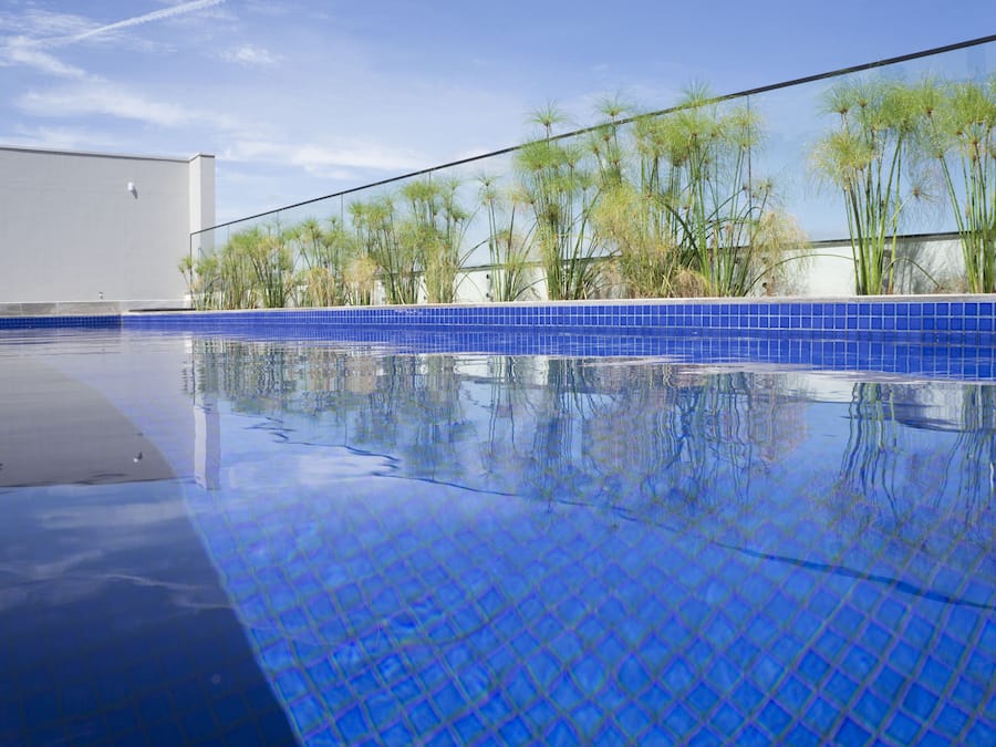 Una piscina al aire libre, sillones reclinables de piscina