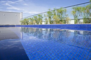 Una piscina al aire libre, tumbonas