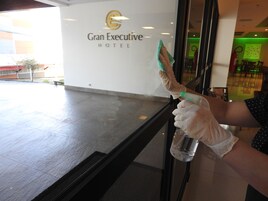 Una persona limpiando una ventana en el Hotel Gran Executive.