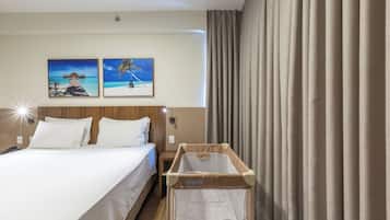 Habitació d'hotel amb un llit, una tauleta de nit, una llitera penjant i dos quadres al mur.