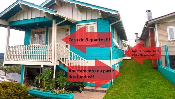 Une maison à deux étages avec un balcon et un petit jardin.