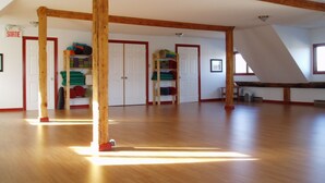 Un'ampia stanza con travi in legno, una zona soppalcata e una porta con la scritta 'SORTIE'.