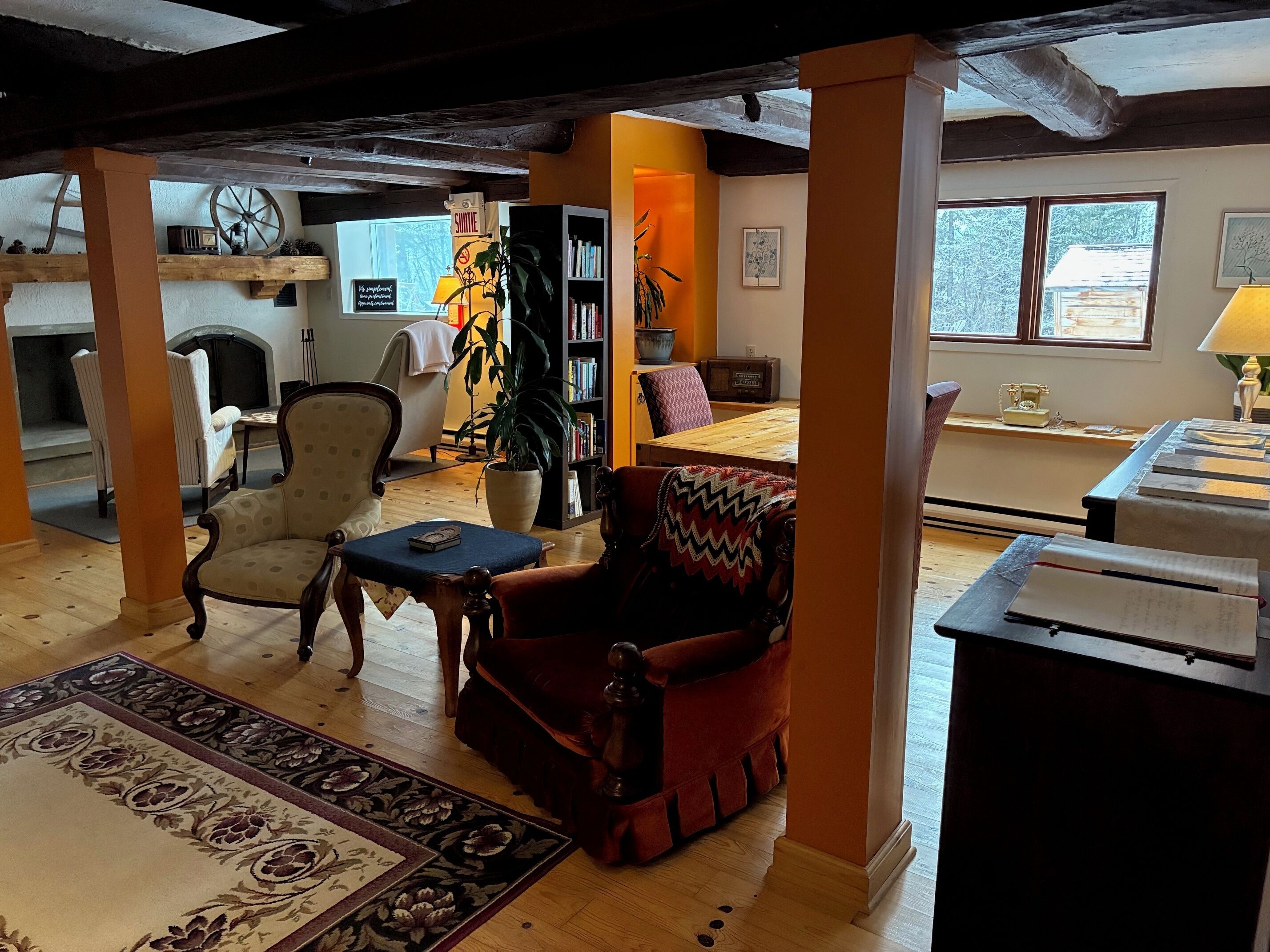 A cozy living room with a fireplace, a bookshelf, and a dining area with a table and chairs.