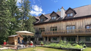 Un grande edificio in legno con numerosi balconi e un giardino curato.