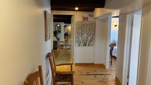 Un corridoio con pavimento in legno, una panchina, una targa appesa al muro con la scritta “SOUTIE” e una porta che dà su un'altra stanza.
