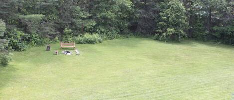 A grassy field with a bench and a picnic table.