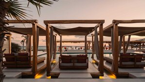 A wooden deck with cushioned seating and a pool, overlooking the ocean. - Branco Mykonos (Mykonos)
