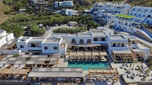 A resort with multiple white buildings, a swimming pool, and outdoor seating areas.