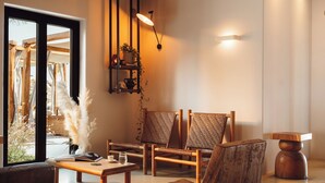 A modern interior with a wooden bench, a table, and a hanging light fixture.