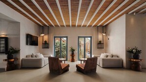 A modern interior with two sofas facing each other, a wooden ceiling, and a view through large windows. - Branco Mykonos (Mykonos)