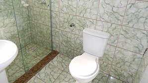 Un baño con inodoro, ducha y lavamanos.