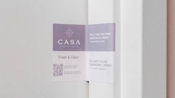 Porta de quarto de hotel com aviso indicando que o espaço foi higienizado e selado por questões de saúde e segurança.