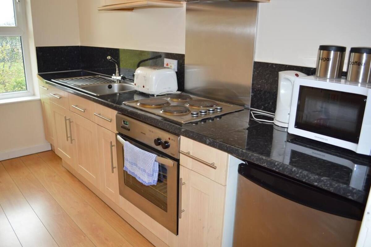 A modern kitchen with a gas stove, oven, microwave, and a toaster.