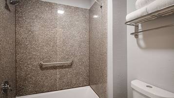 A bathroom with a shower, a bathtub, and a towel rack.