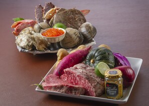 Un plato de comida con carne, almejas y verduras.
