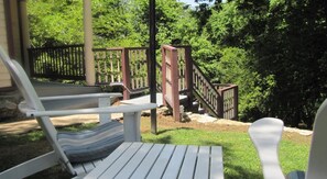 A covered outdoor seating area with a wooden deck and a staircase leading to a higher level. - 5 Ojo Inn Bed and Breakfast (Eureka Springs)