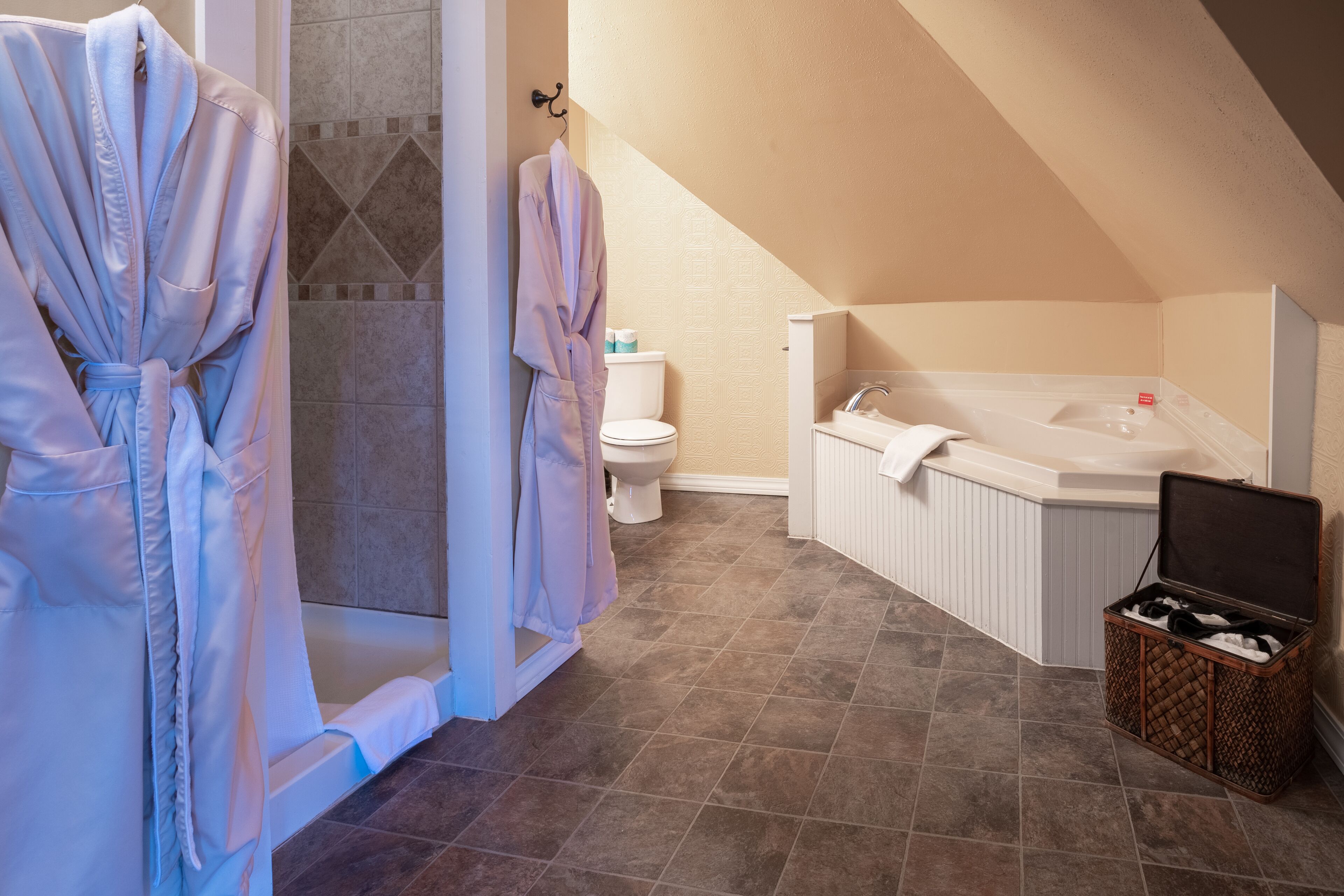 A bathroom with a bathtub, a toilet, and a shower area.