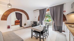 Una cocina moderna con comedor, sofá y chimenea.