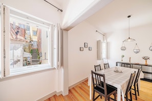 A dining area with a table, chairs, and a view through a window.
