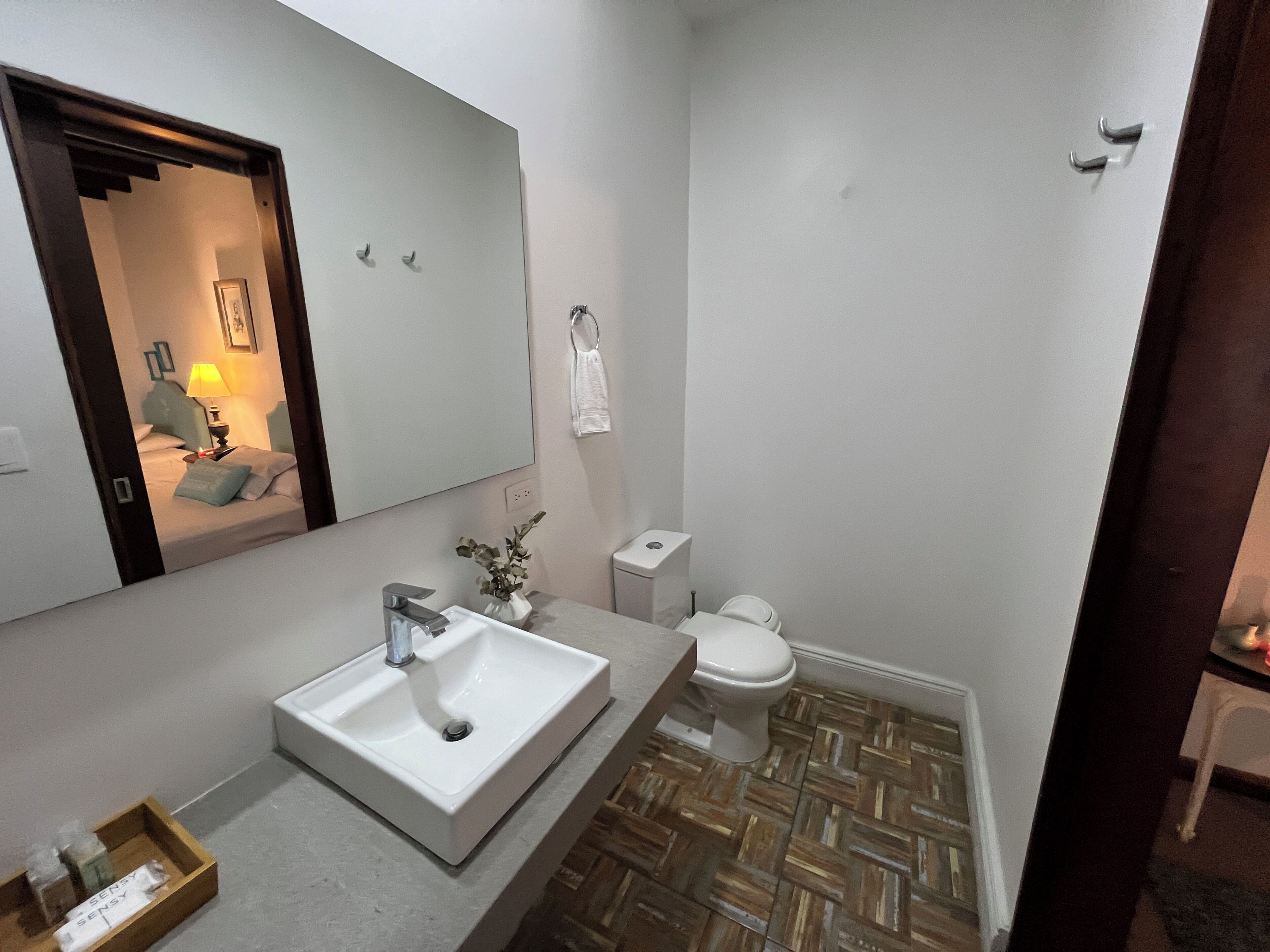 Une salle de bain avec un lavabo, des toilettes et un miroir.