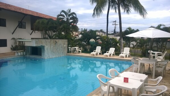 Una piscina al aire libre, sombrillas, tumbonas