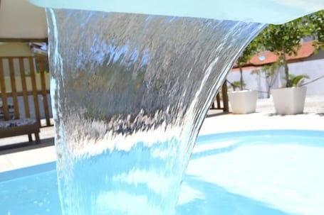 Una piscina al aire libre, sillones reclinables de piscina