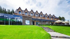 Un edificio moderno con fachada de piedra y varios tejados a dos aguas.