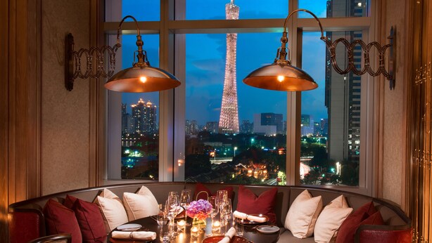 A dining area with a view of the Eiffel Tower at night.