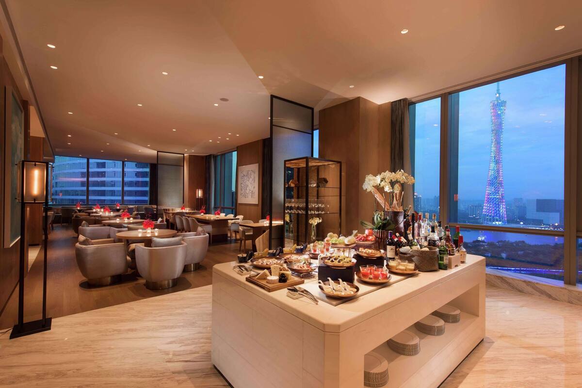 A hotel lobby with a buffet, seating area, and a view of a tower.