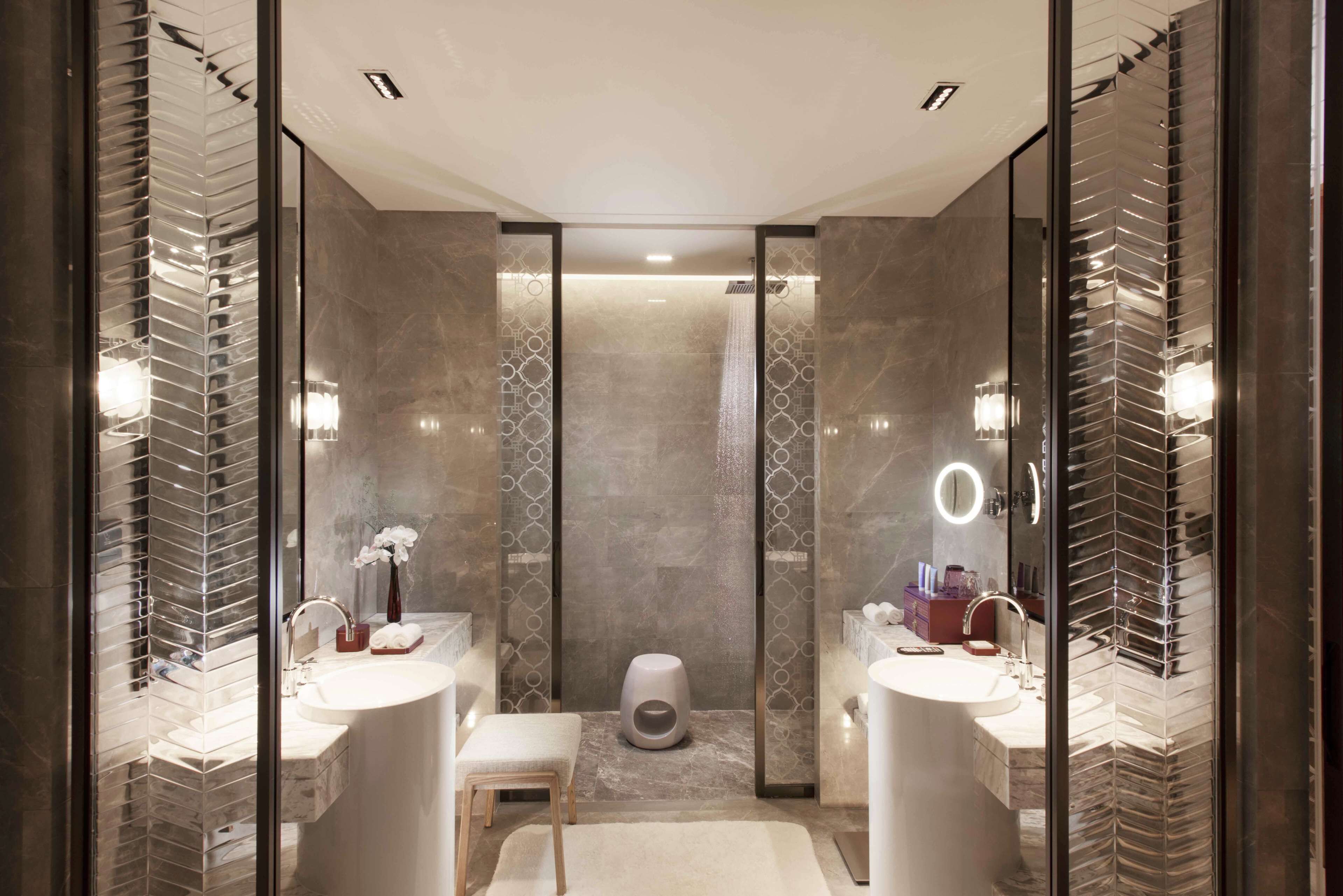 Une salle de bain moderne avec deux lavabos, une douche et des toilettes.