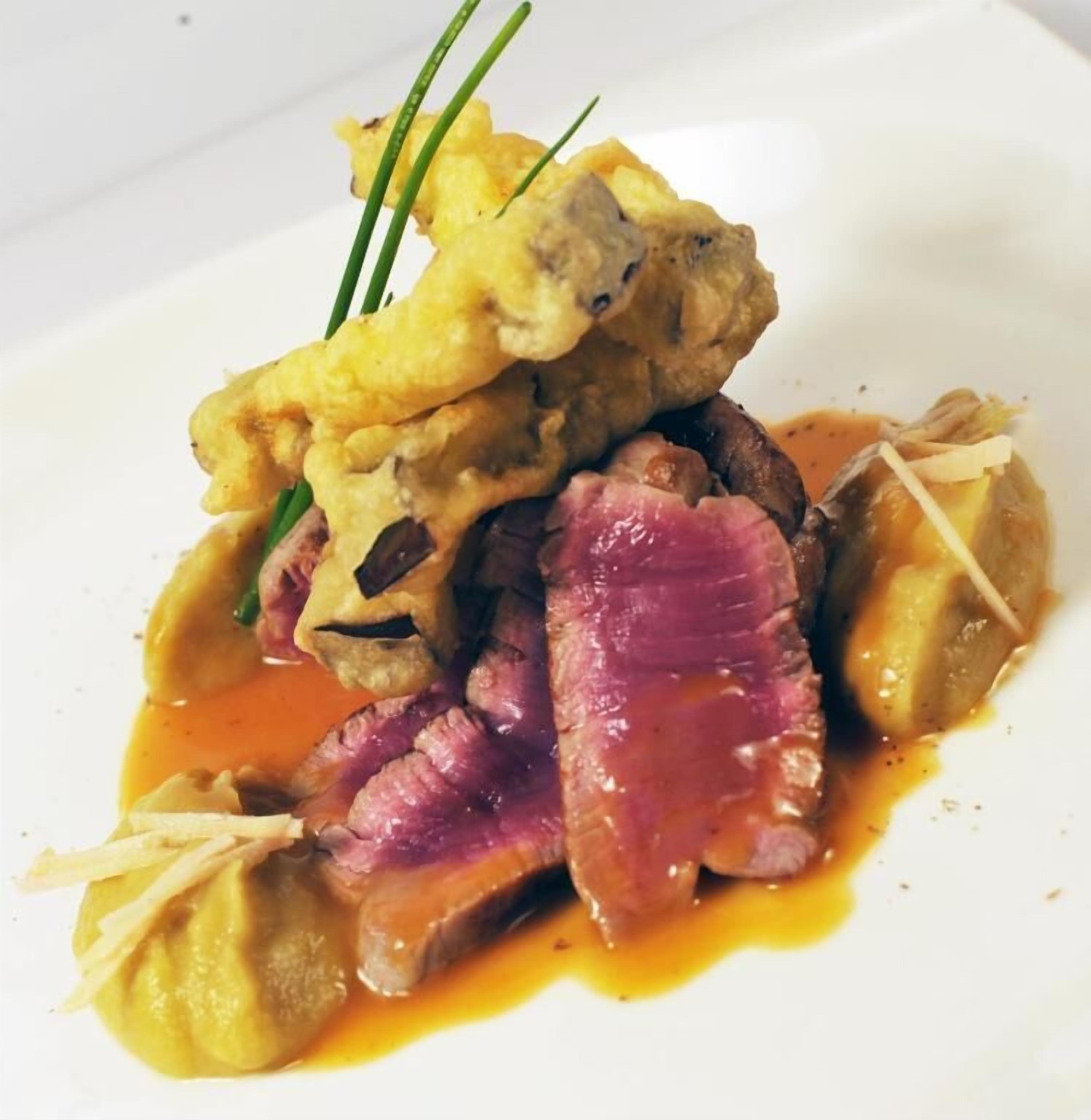 Un plat composé de viande, de légumes et d’une sauce.