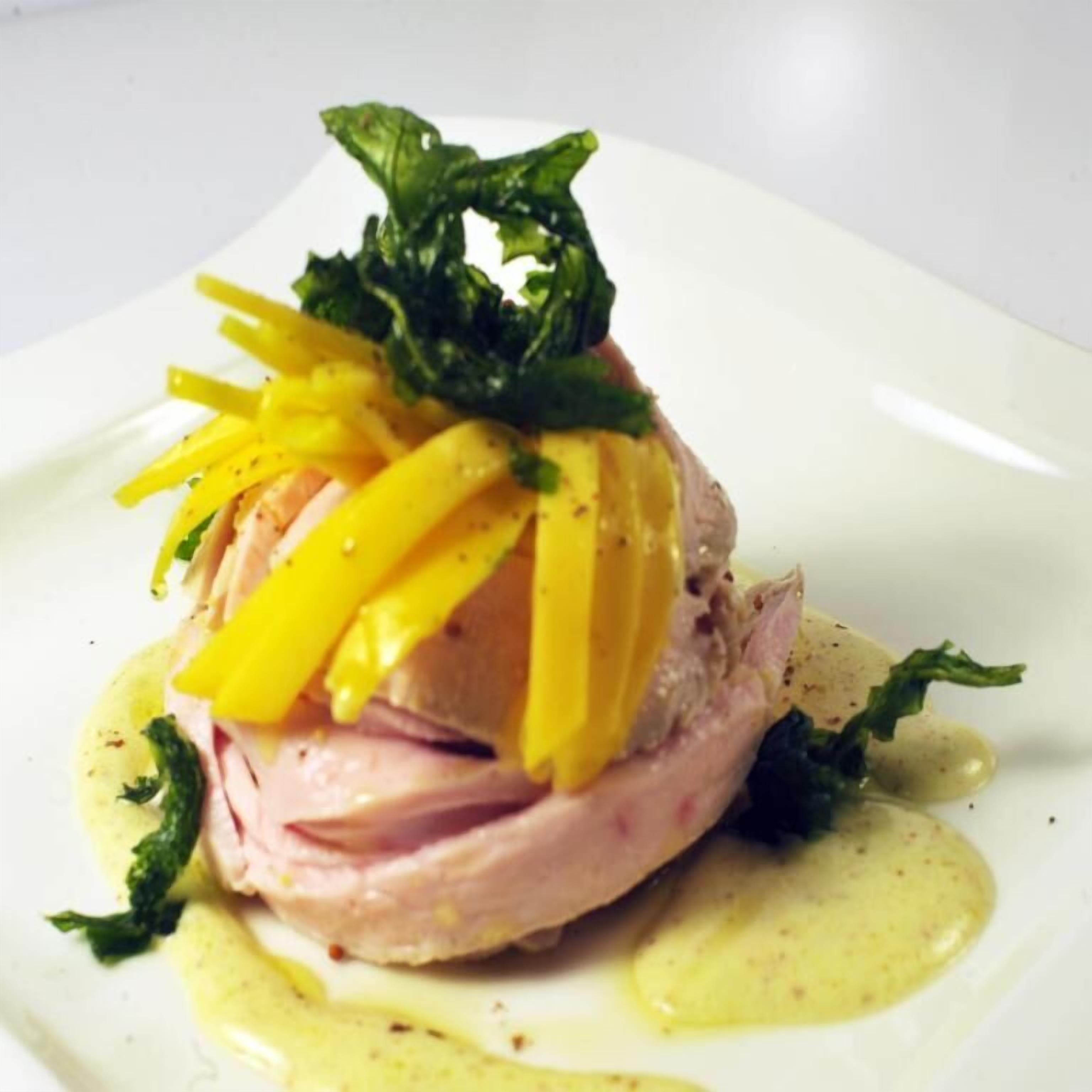 Ein angerichtetes Gericht mit Fleisch, gelbem Käse und Salat.