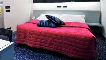 Une chambre d’hôtel avec un grand lit, une table de chevet et une chaise.