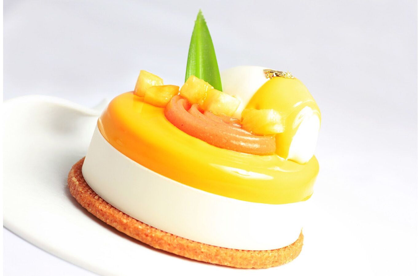 A dessert with a white base, yellow topping, and pineapple pieces, served on a round, toasted base.