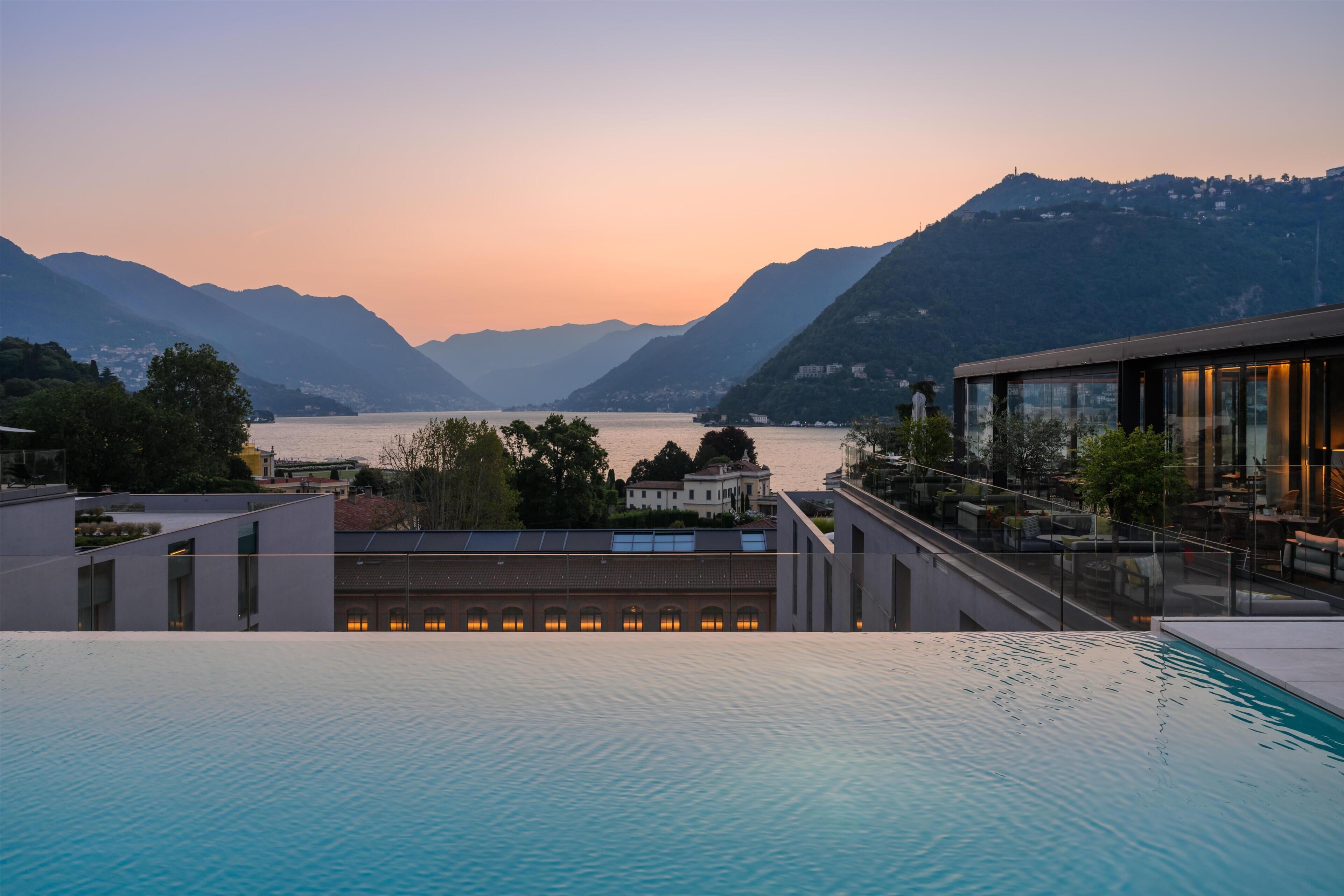 A swimming pool with a view of mountains and a body of water.