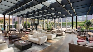 Un espacio interior amplio con diversas opciones de asientos, ventanas grandes y un diseño arquitectónico moderno.
