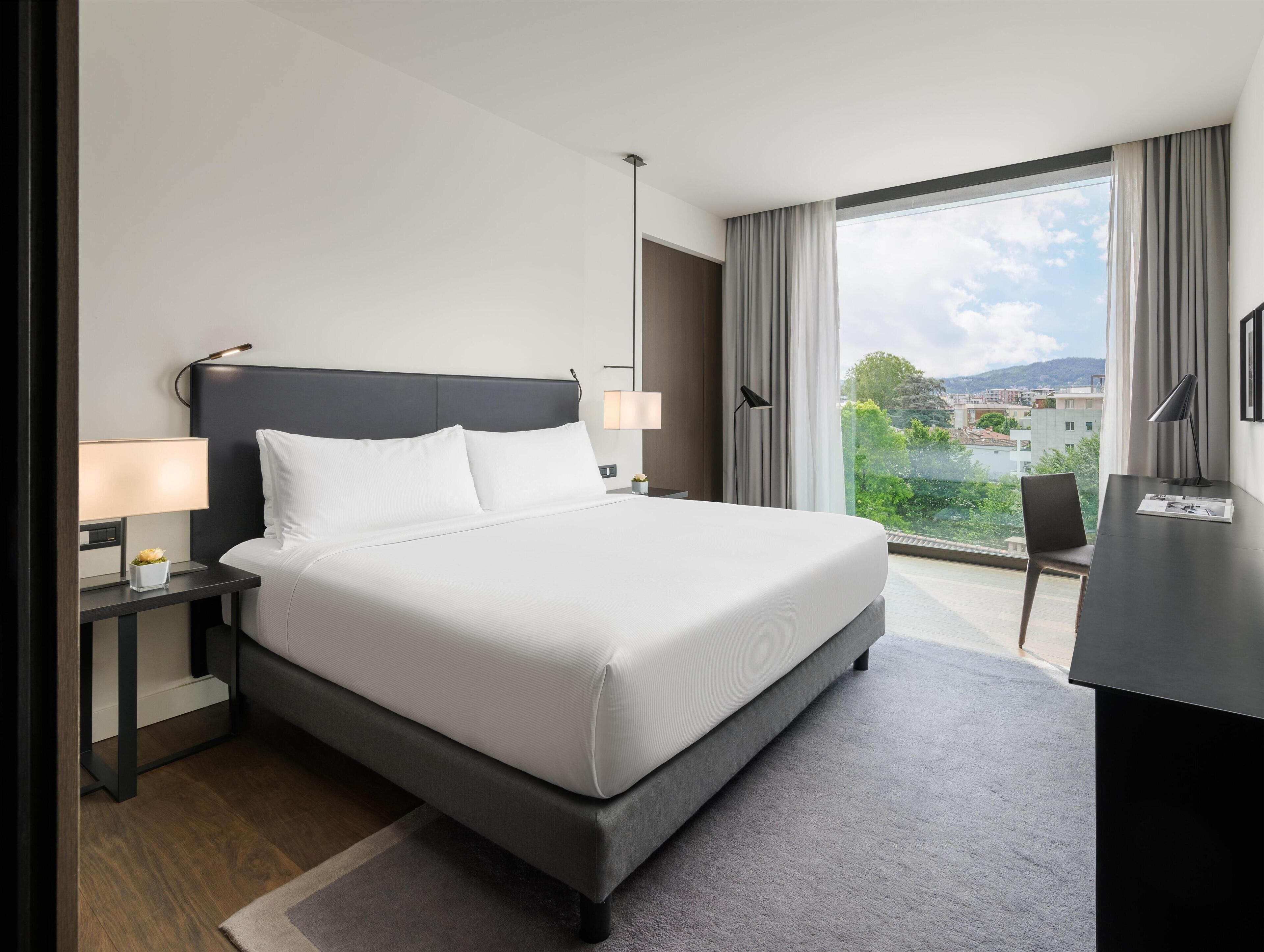 Deluxe-huone, 1 suuri parisänky, kaupunkinäköala | Untuvapeitot, tallelokero huoneessa, yksilöllisesti kalustettu, työpöytä