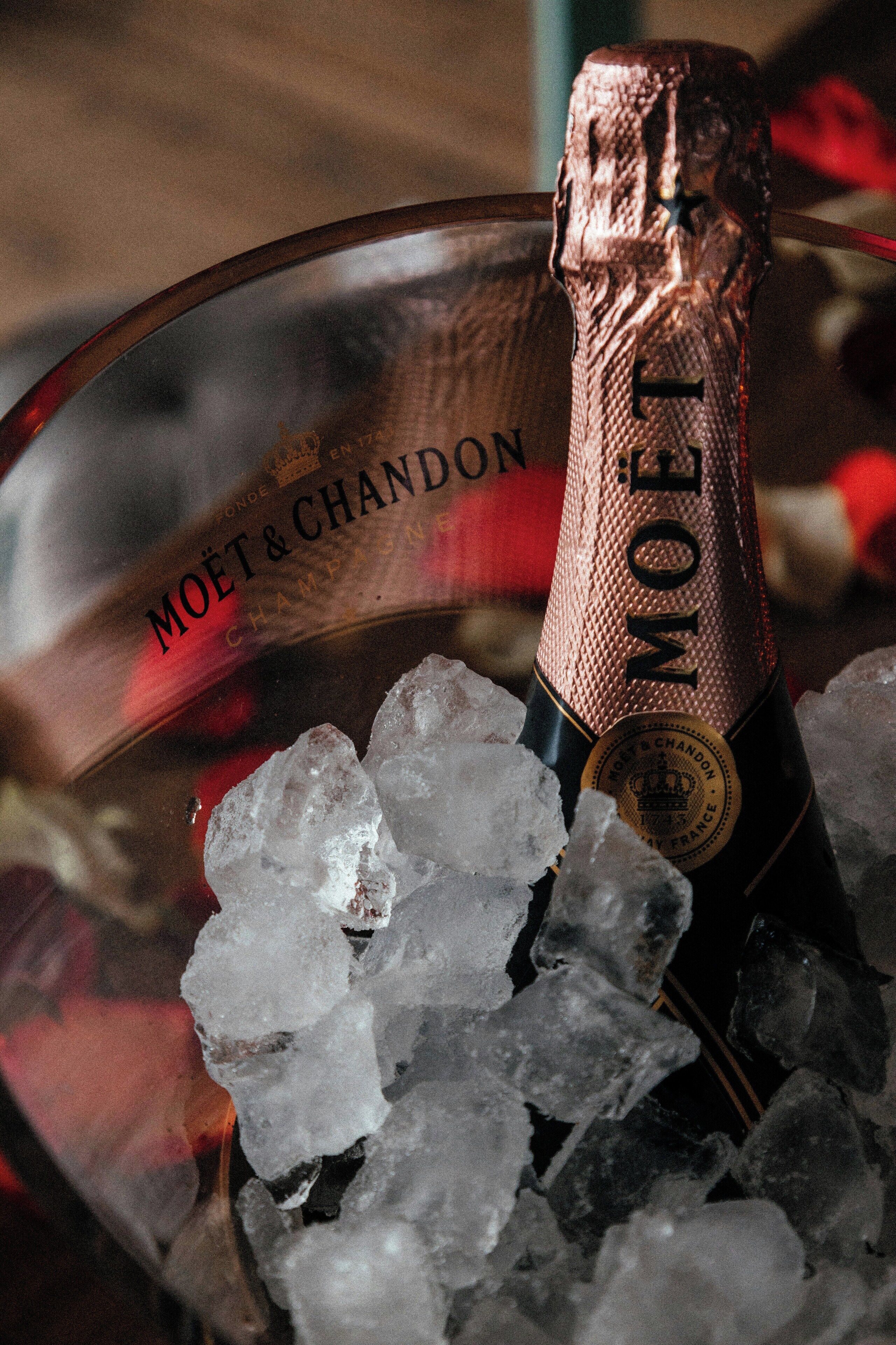 Una botella de champán Moët & Chandon en una copa rodeada de cubitos de hielo.
