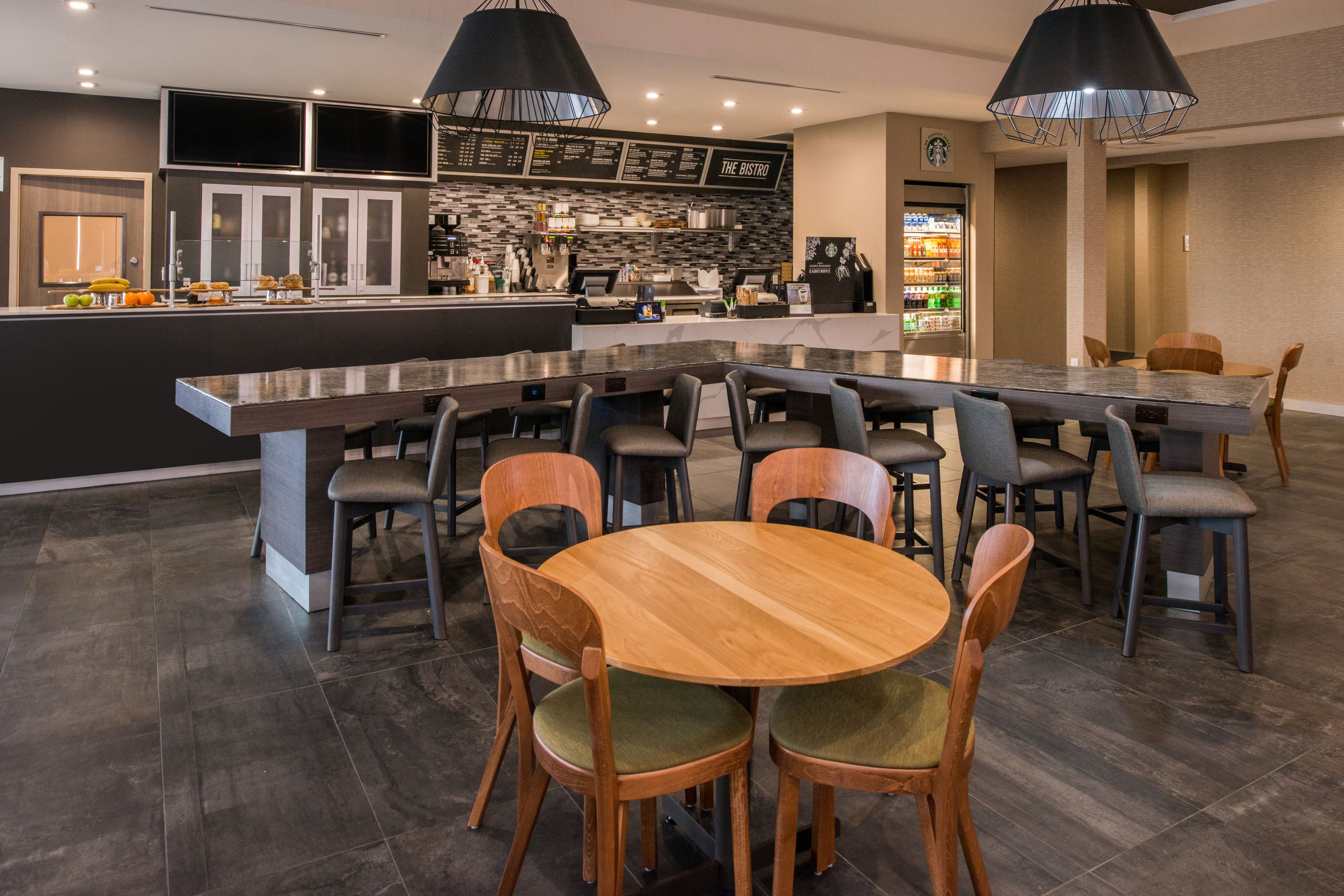 Un comedor moderno con una isla central, distintas opciones de asientos y una zona de bar al fondo.