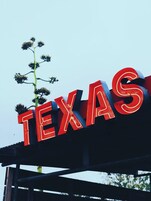 A sign with the word "TEXAS" in large red letters.