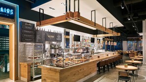 A modern café with a wooden counter, menu boards, and seating area. - Element by Marriott Austin Downtown (Austin)