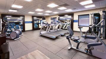 A gym with treadmills, elliptical machines, and weight equipment.