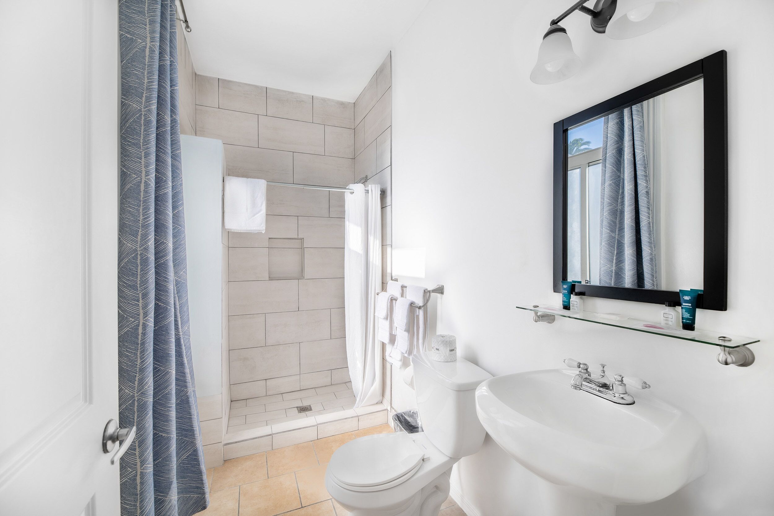 A modern bathroom with a shower, toilet, and sink.