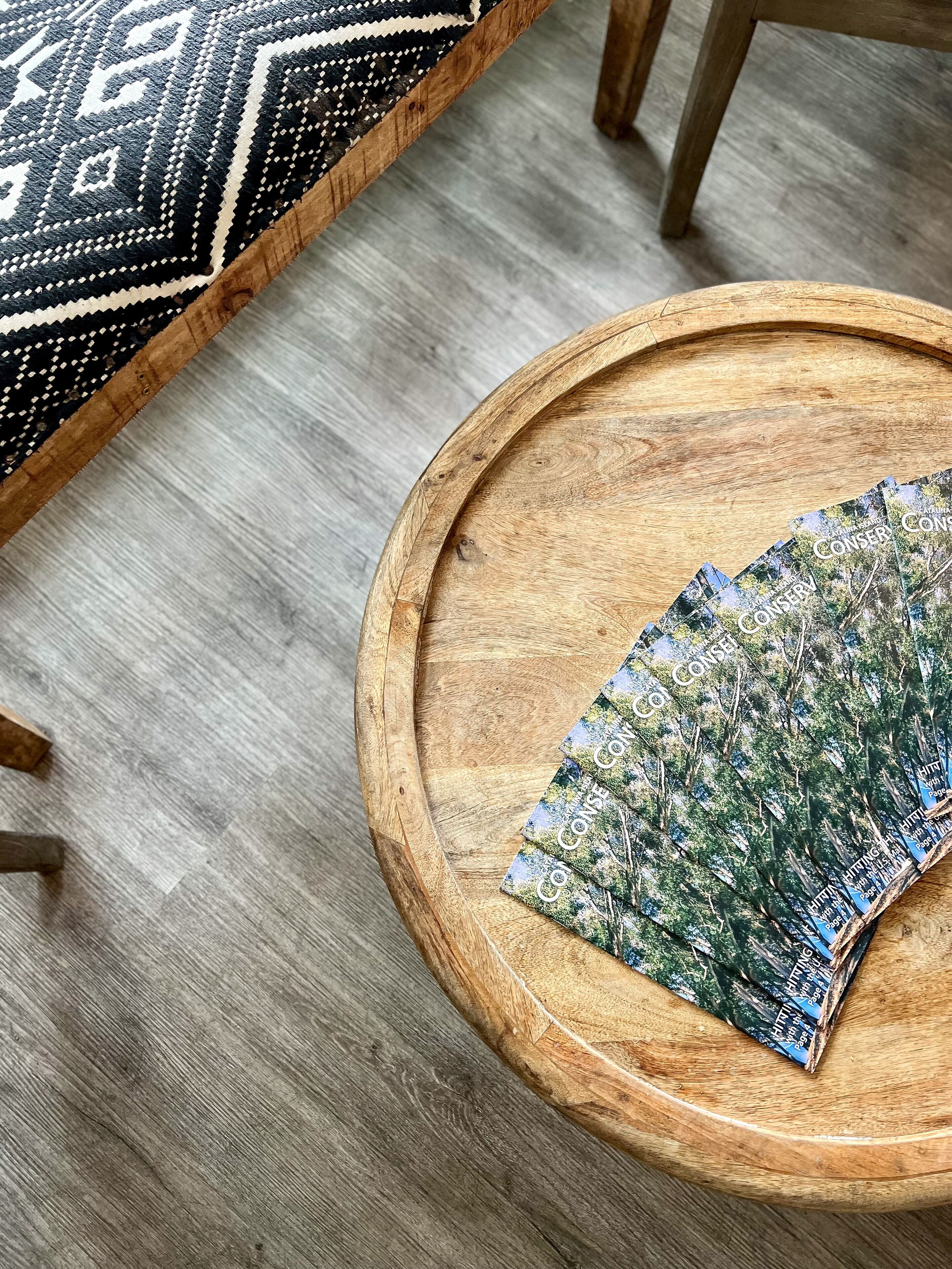 A round wooden tray with a patterned fabric on a wooden table.