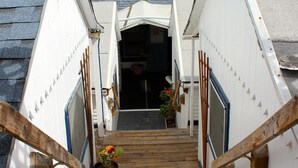 A wooden staircase leading to a building with a sloped roof. - Hermosa Hotel (Avalon)